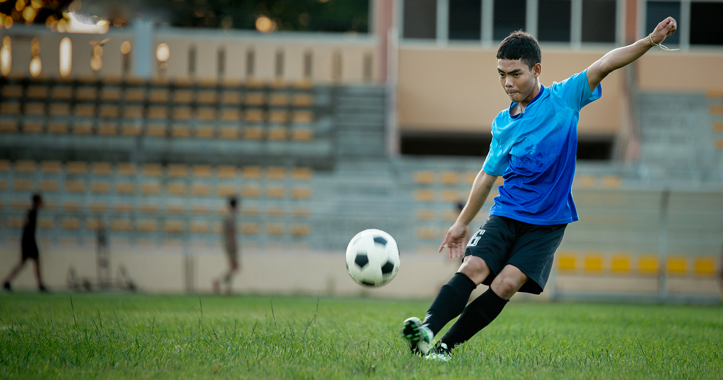 Student playing football on campus